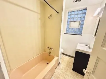 a white toilet sitting next to a shower