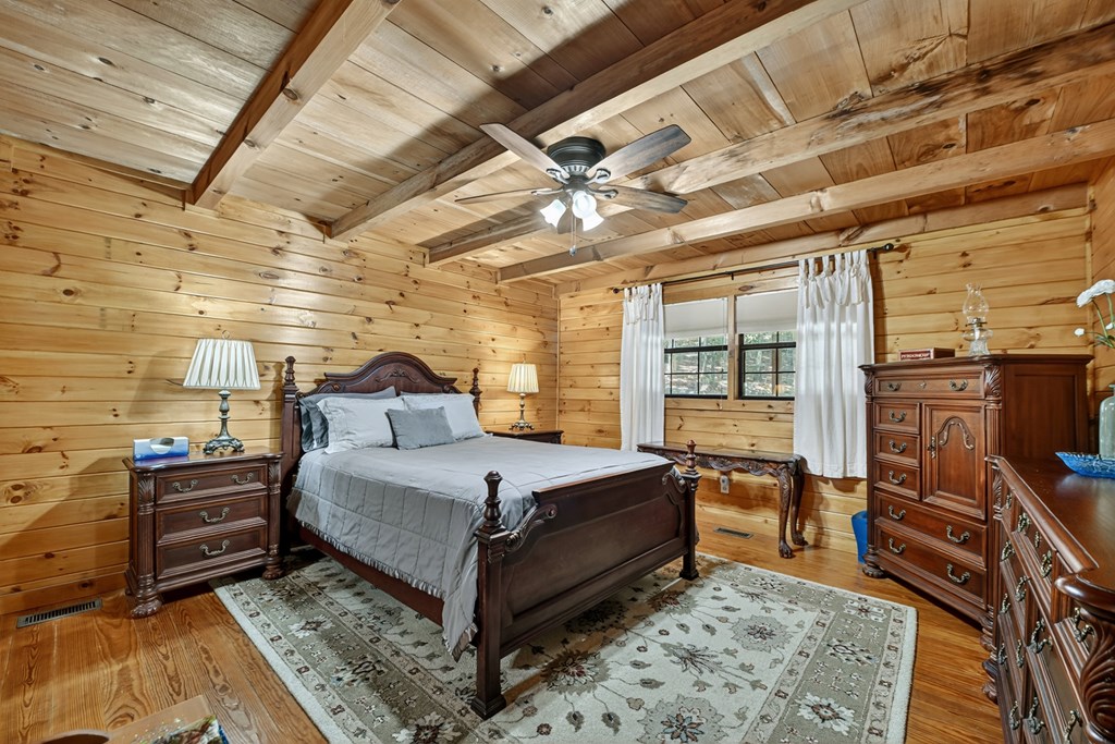 1431 Cashes Valley Lane Cherry Log, GA 30522 - Photo 15 of 57 a spacious bedroom with a bed and wooden floor