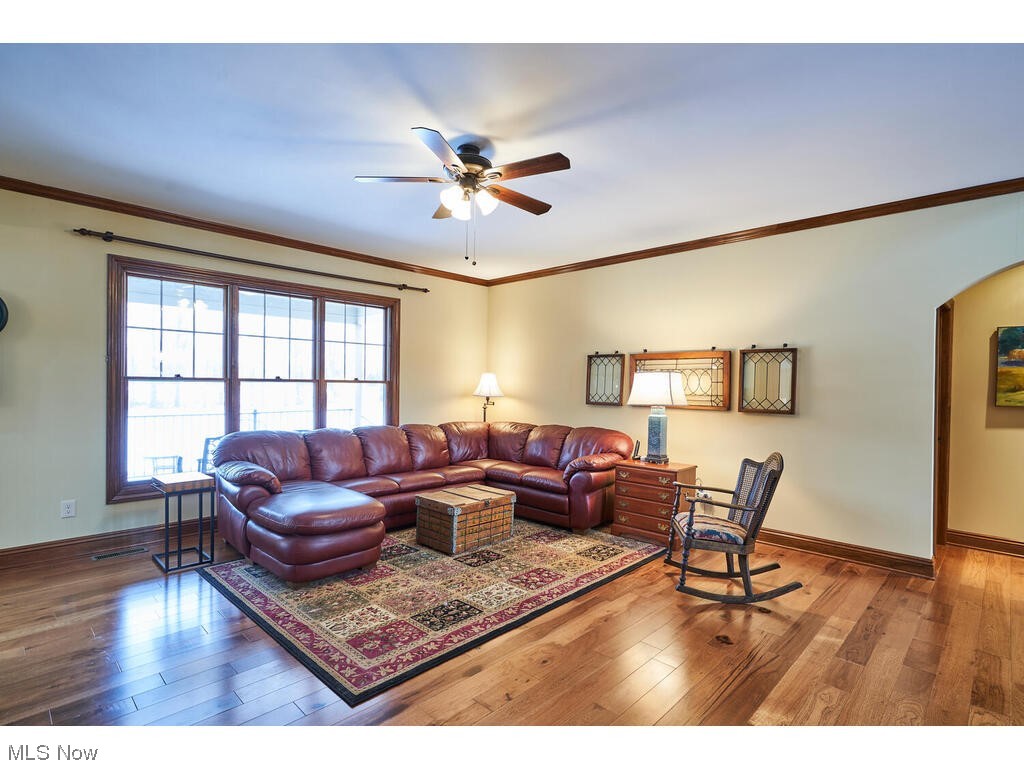 5677 Spring Ridge Drive Medina, OH 44256 - Photo 8 of 33 Living room with crown molding, ceiling fan, and wide planked hickory floors