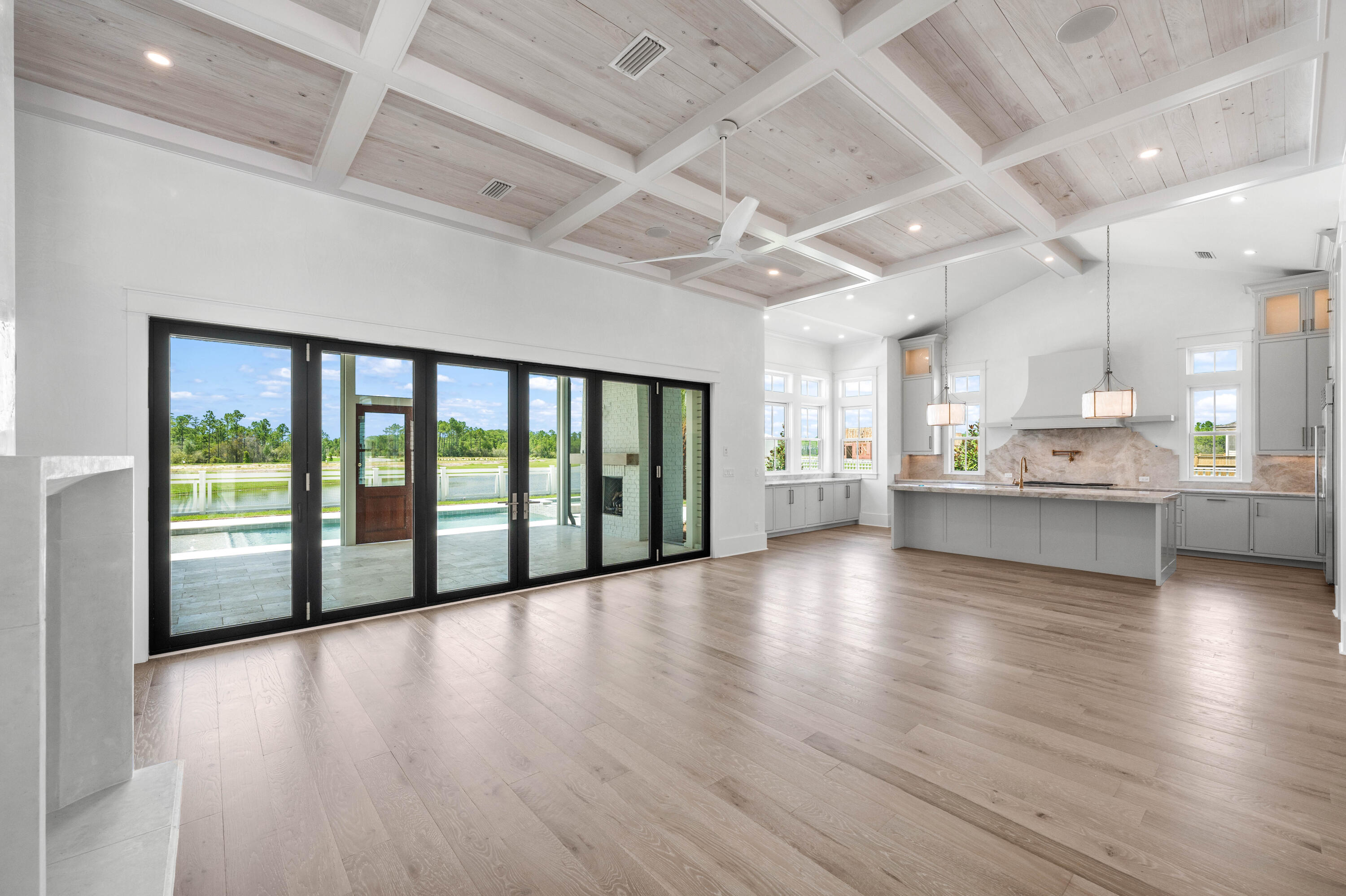 65 Morning Lgt Way Watersound, FL 32461 - Photo 11 of 59 a view of an empty room with wooden floor and a kitchen