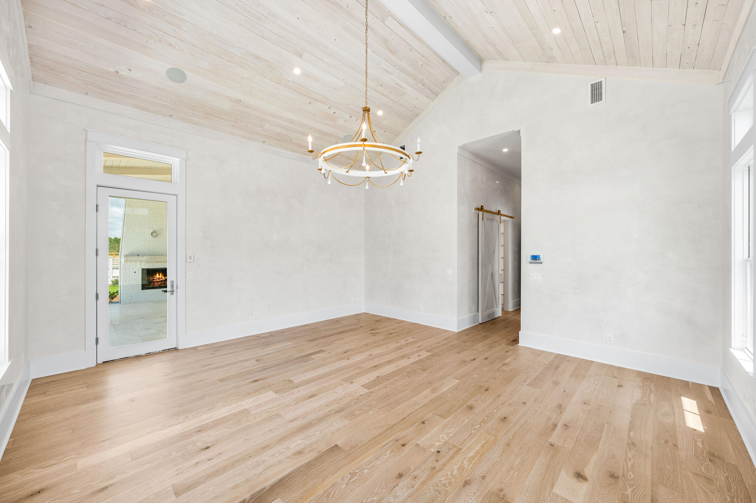 65 Morning Lgt Way Watersound, FL 32461 - Photo 17 of 59 an empty room with wooden floor chandelier fan and windows