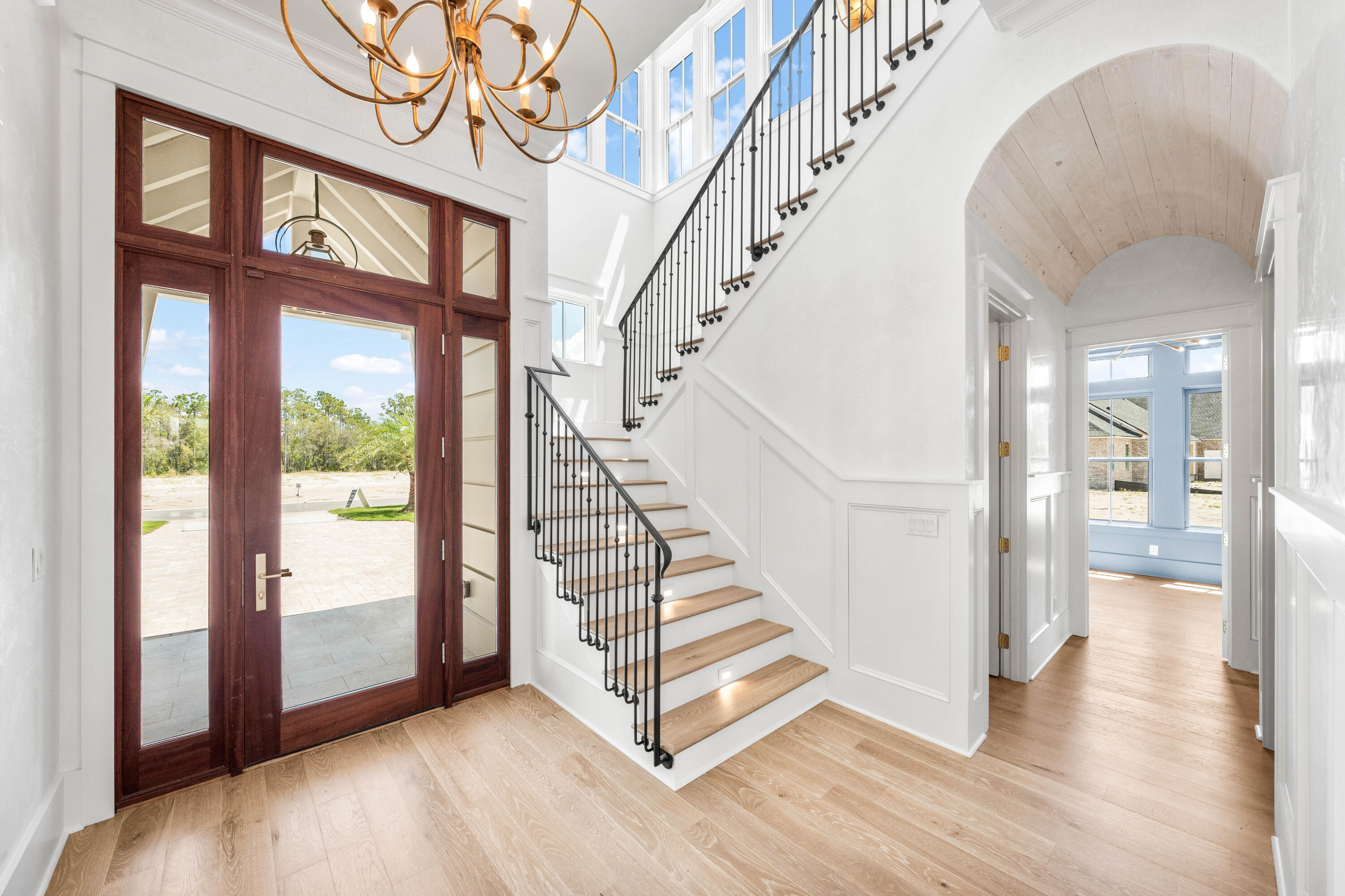 65 Morning Lgt Way Watersound, FL 32461 - Photo 21 of 59 a view of an entryway with wooden floor leading to a furnished livingroom and windows