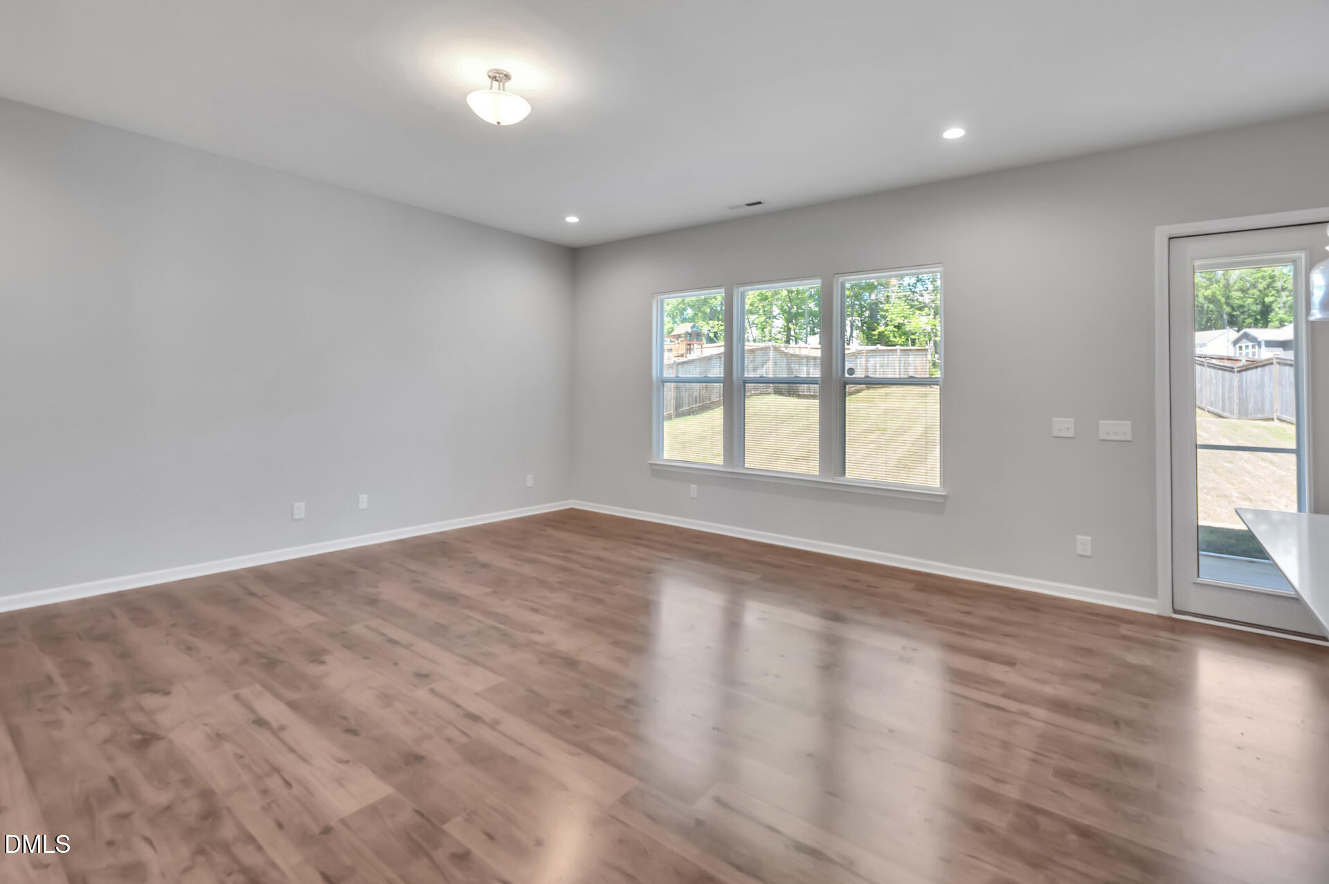 5406 Ripplebrook Drive Durham, NC 27712 - Photo 17 of 37 an empty room with wooden floor and windows
