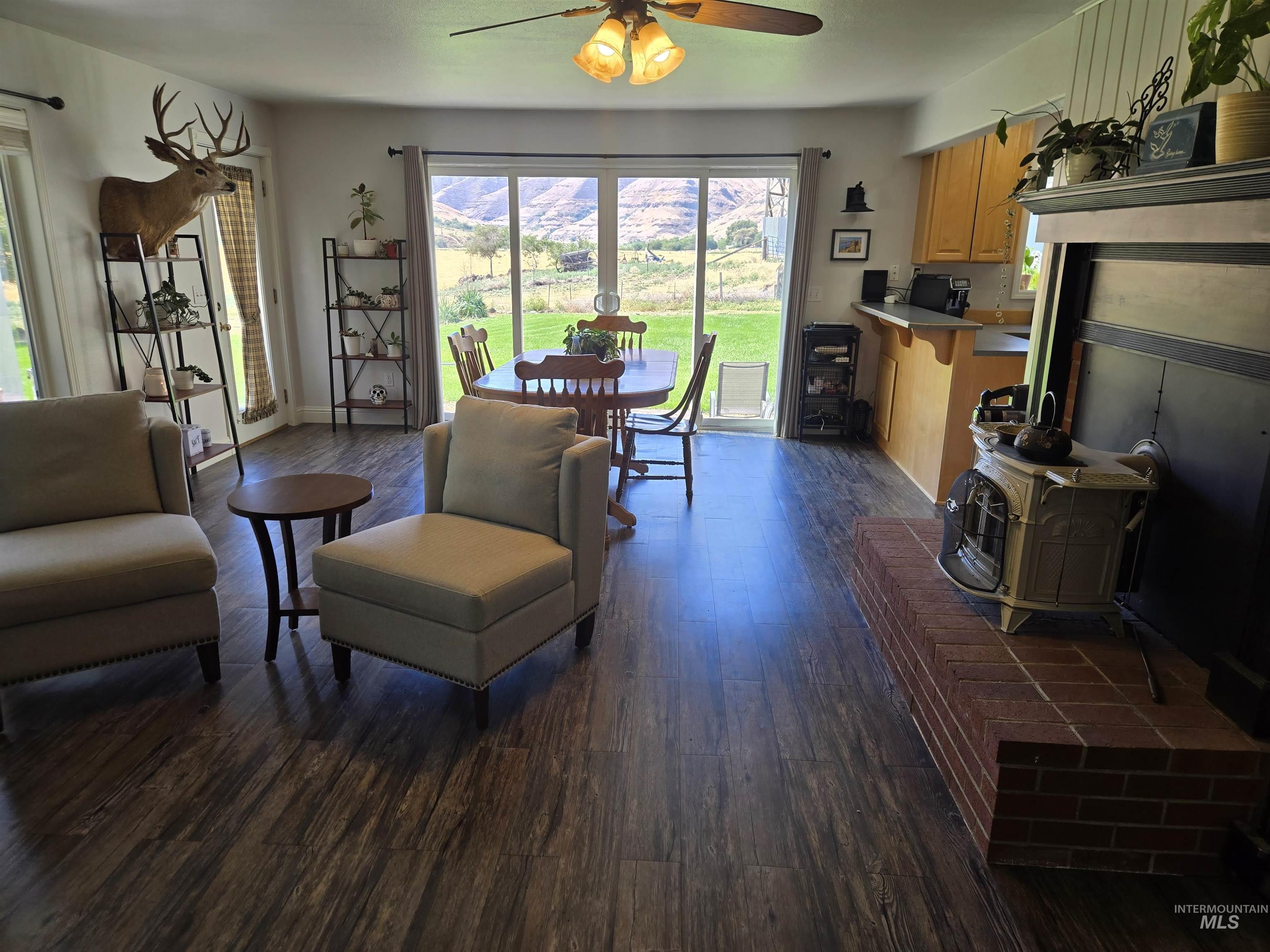 17082 Snake River Road Asotin, WA 99402 - Photo 28 of 31 Living room with dark wood-style floors, ceiling fan, and a wood stove