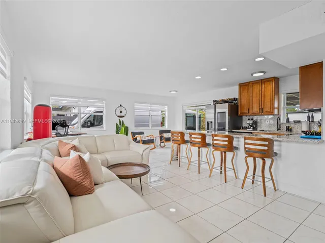 a living room with furniture and a view of kitchen