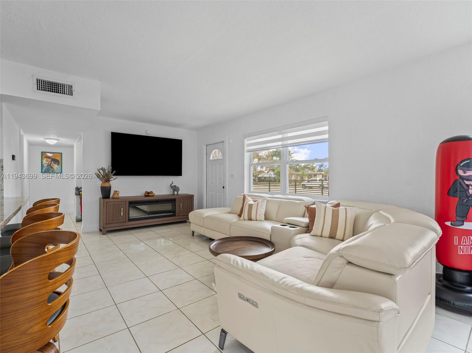11401 Southwest 56th Street Miami, FL 33165 - Photo 10 of 37 a living room with furniture and a flat screen tv