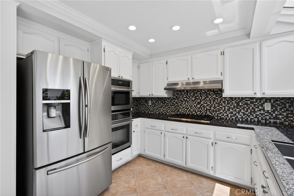 19468 Kilfinan Street Porter Ranch, CA 91326 - Photo 19 of 48 a kitchen with granite countertop white cabinets and stainless steel appliances