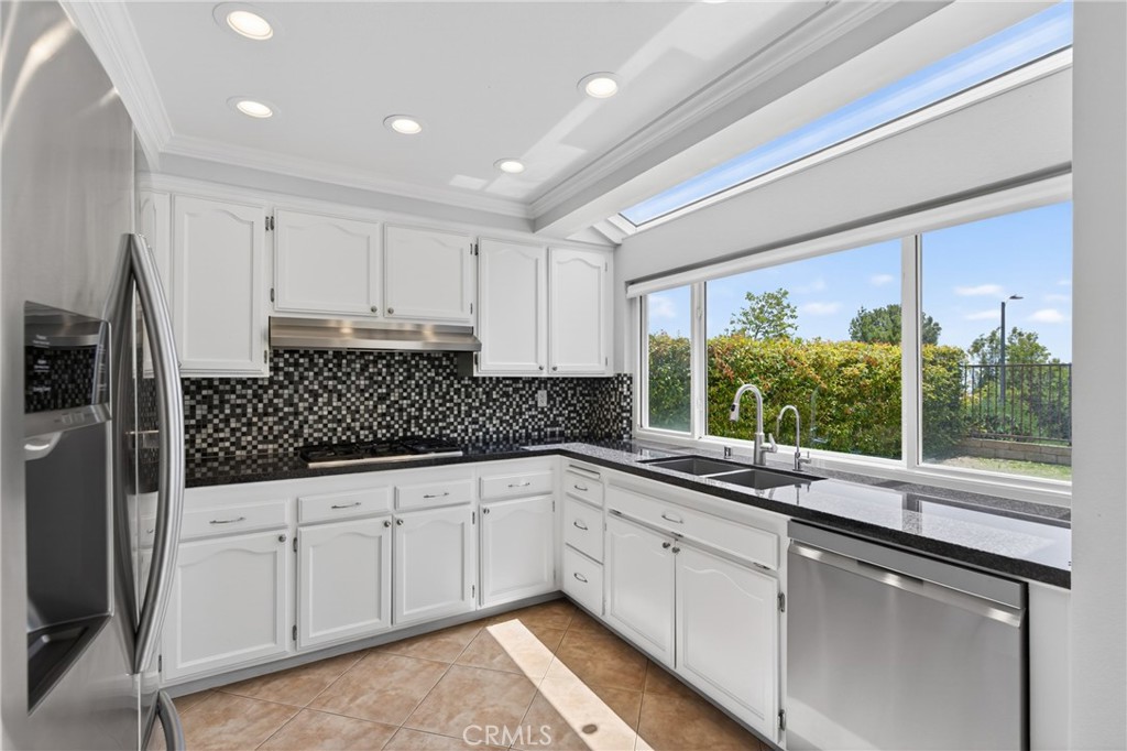 19468 Kilfinan Street Porter Ranch, CA 91326 - Photo 2 of 48 a kitchen with granite countertop a sink and white cabinets