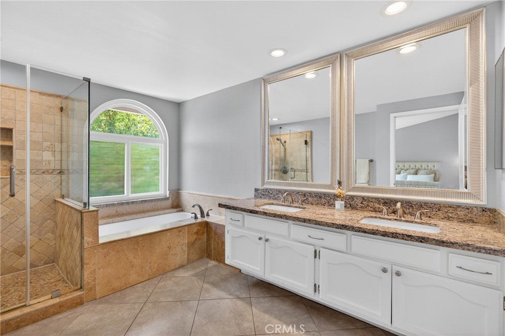 19468 Kilfinan Street Porter Ranch, CA 91326 - Photo 28 of 48 a spacious bathroom with a granite countertop tub sink and mirror