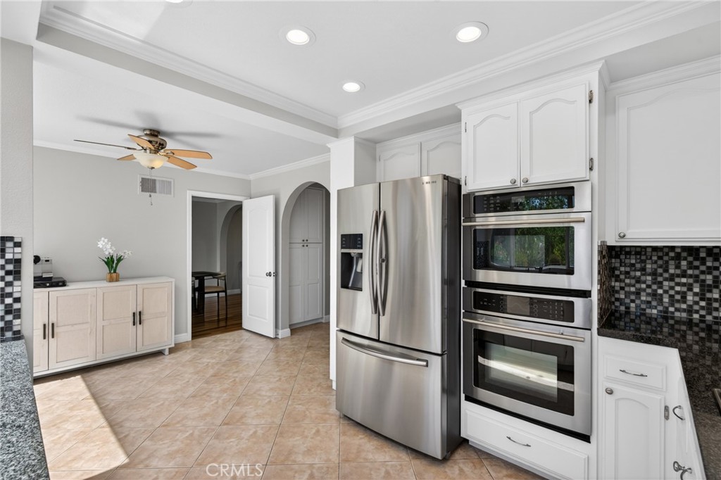19468 Kilfinan Street Porter Ranch, CA 91326 - Photo 4 of 48 a kitchen with stainless steel appliances and white cabinets