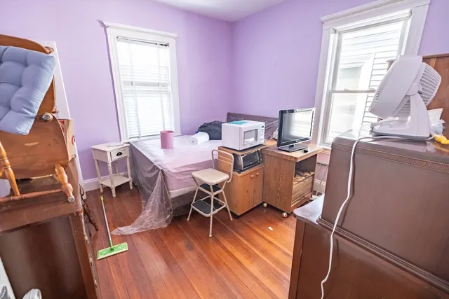 a work room with furniture a window and wooden floor