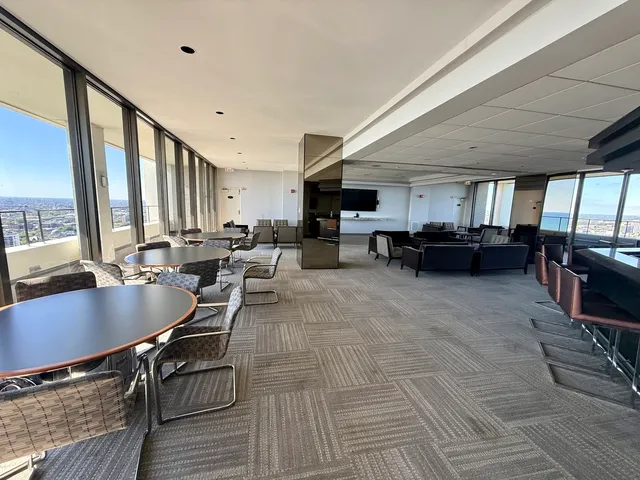 a living room with furniture kitchen view and a large window