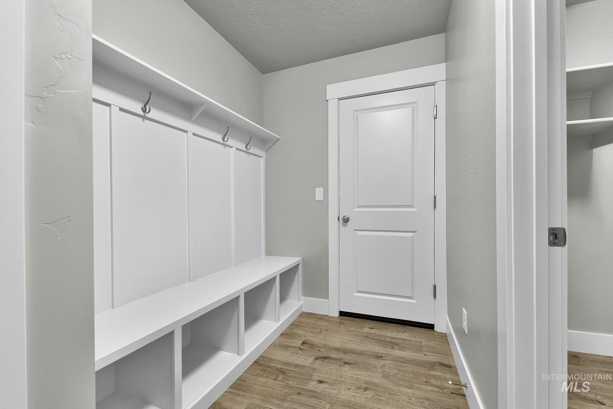 320 North 12th Parma, ID 83660 - Photo 12 of 34 Built-in storage bench with hooks, wood-finish flooring, two-panel interior doors, and a closet with shelving