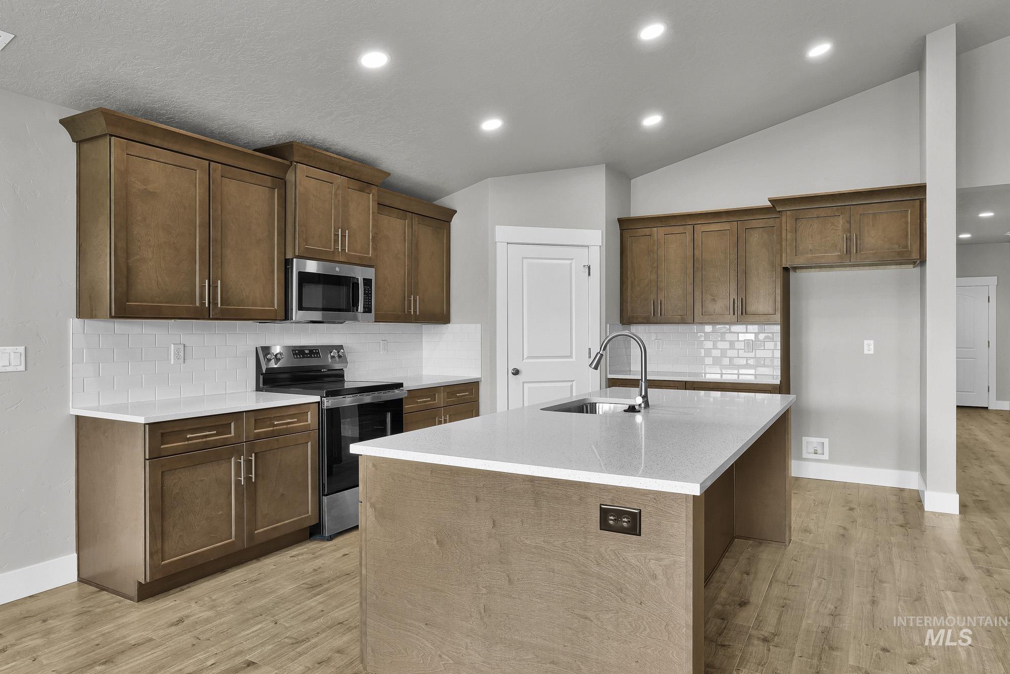 320 North 12th Parma, ID 83660 - Photo 21 of 34 Kitchen featuring wood-finish cabinetry, stainless steel appliances, white subway tile backsplash, and light-tone countertops