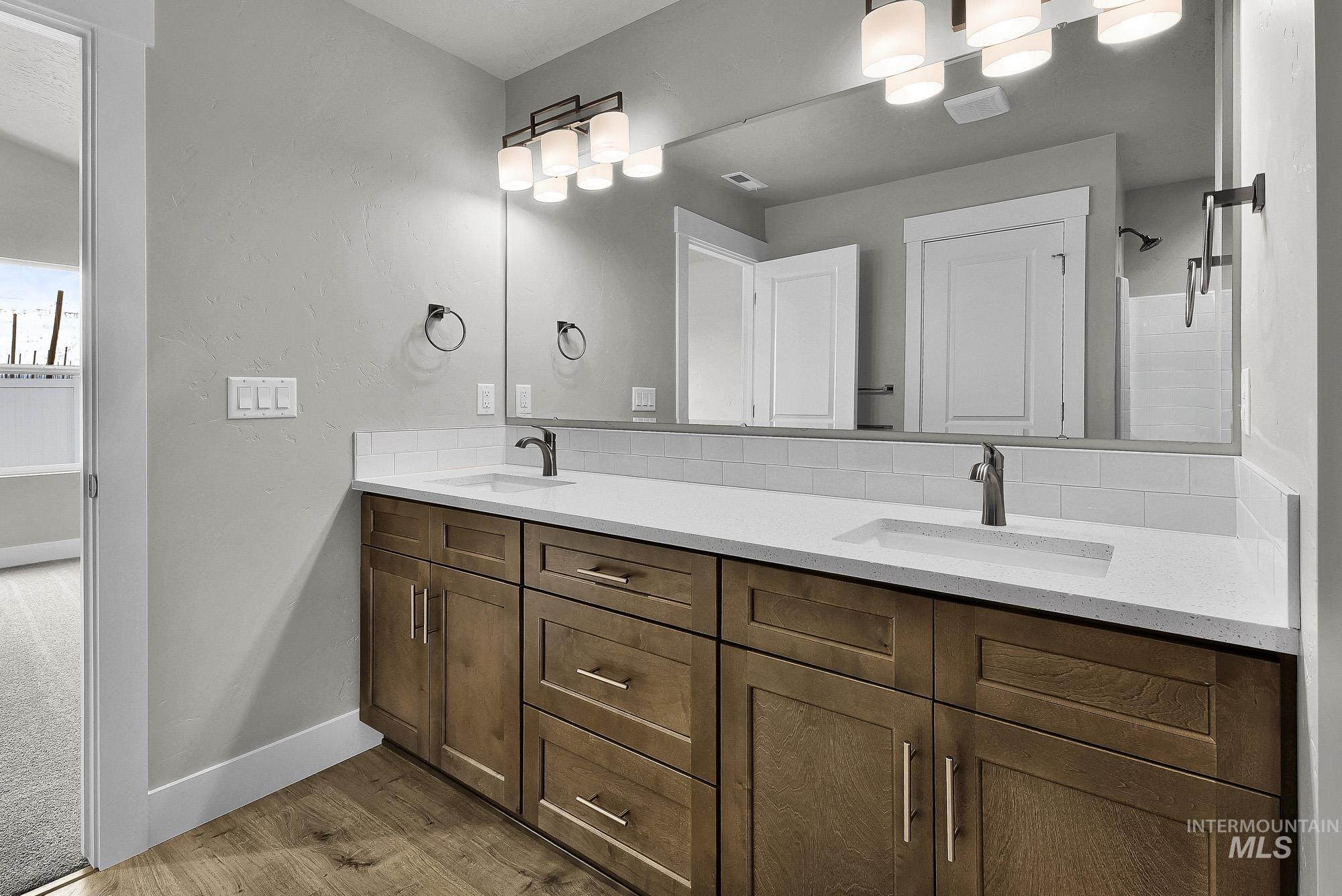 320 North 12th Parma, ID 83660 - Photo 27 of 34 Double vanity featuring wood-finish cabinetry, integrated sinks, and polished hardware
