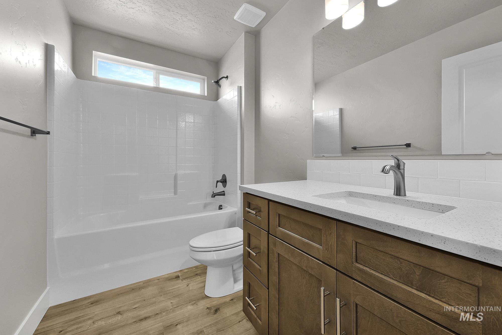 320 North 12th Parma, ID 83660 - Photo 33 of 34 Bathroom featuring a wood-finish vanity with a light-colored countertop, an integrated sink, and a large wall-mounted mirror