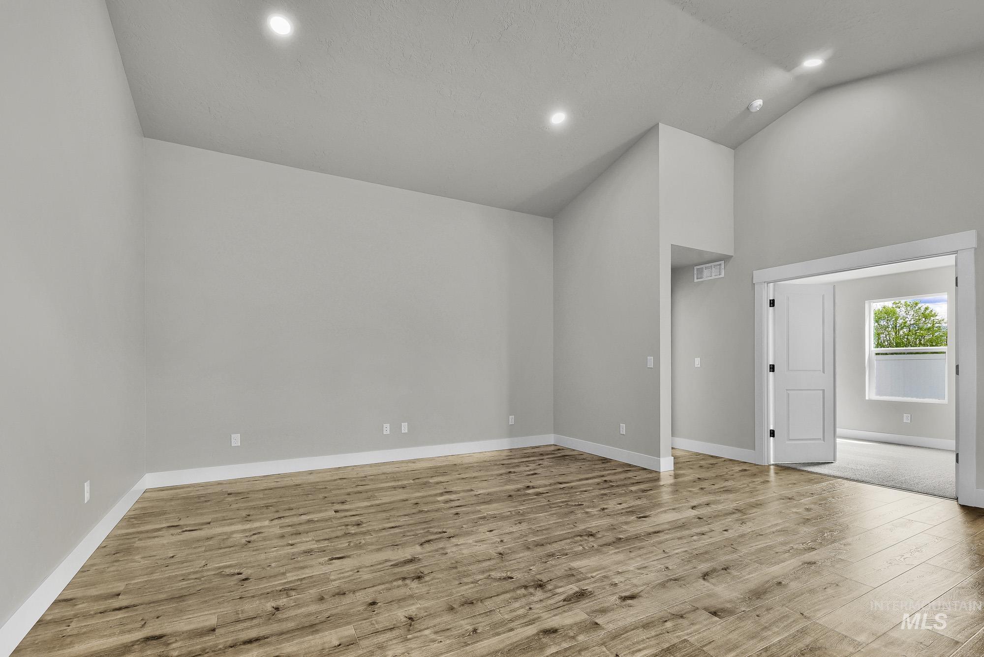 320 North 12th Parma, ID 83660 - Photo 4 of 34 Spacious room featuring vaulted ceilings, recessed lighting, wood-finish flooring, and white baseboards