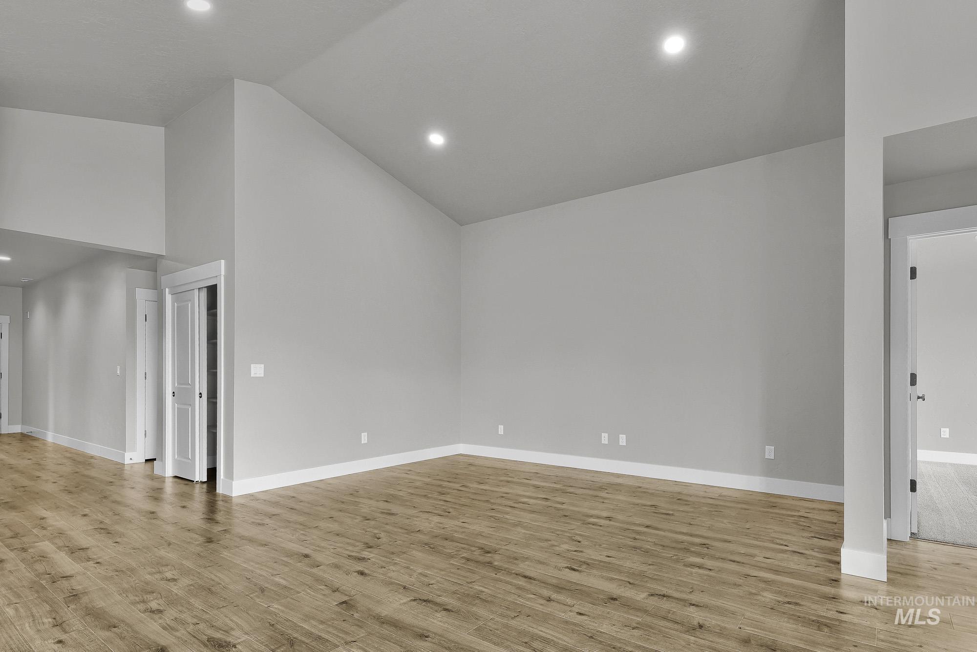 320 North 12th Parma, ID 83660 - Photo 5 of 34 Spacious room featuring vaulted ceilings, recessed lighting, wood-finish flooring, light gray wall paint, and white trim