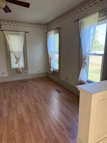 a view of empty room with wooden floor