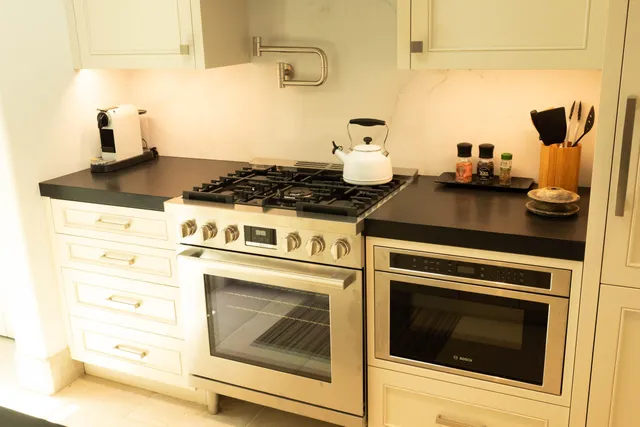 a stove top oven sitting inside of a kitchen