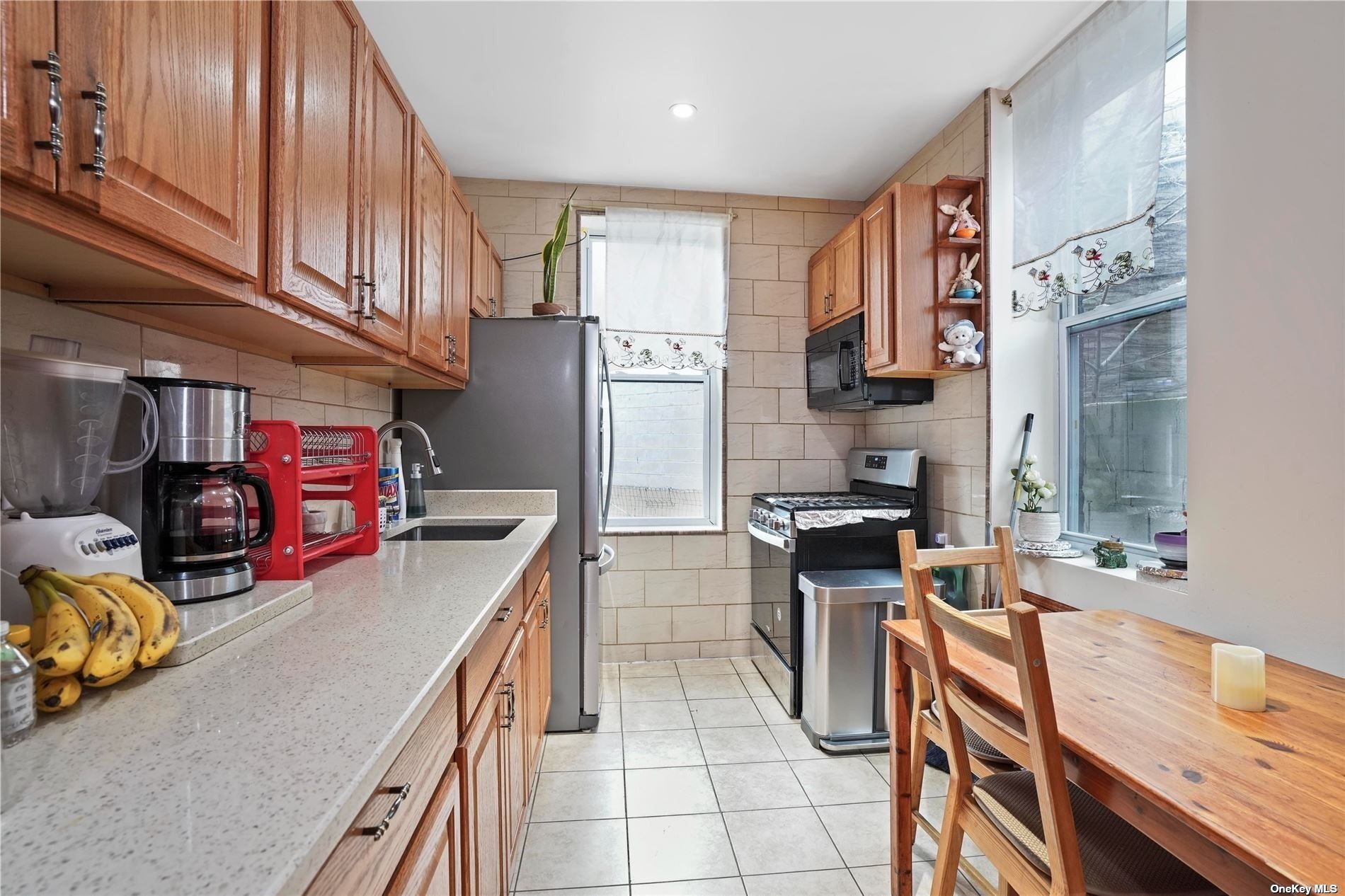 18-11 Centre Street Queens, NY 11385 - Photo 10 of 27 a kitchen with stainless steel appliances granite countertop a stove a sink and a refrigerator