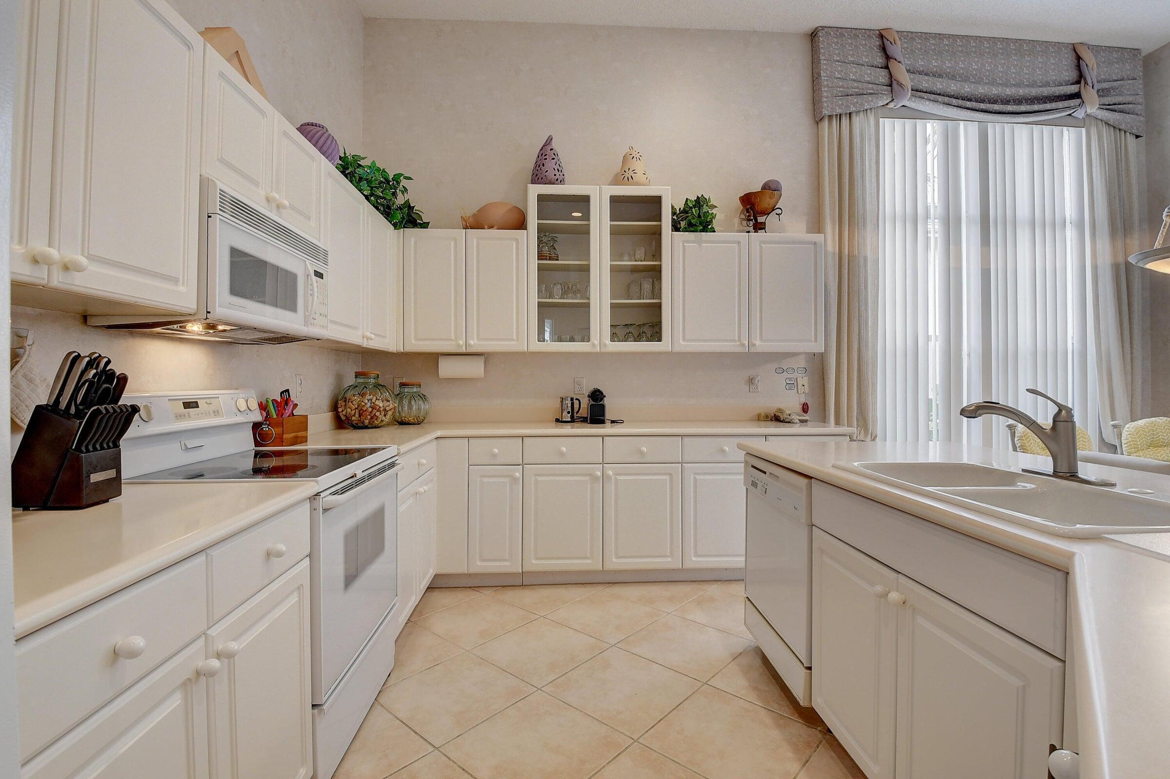 7725 Rockford Road Boynton Beach, FL 33472 - Photo 11 of 47 a kitchen with granite countertop a sink stainless steel appliances and cabinets