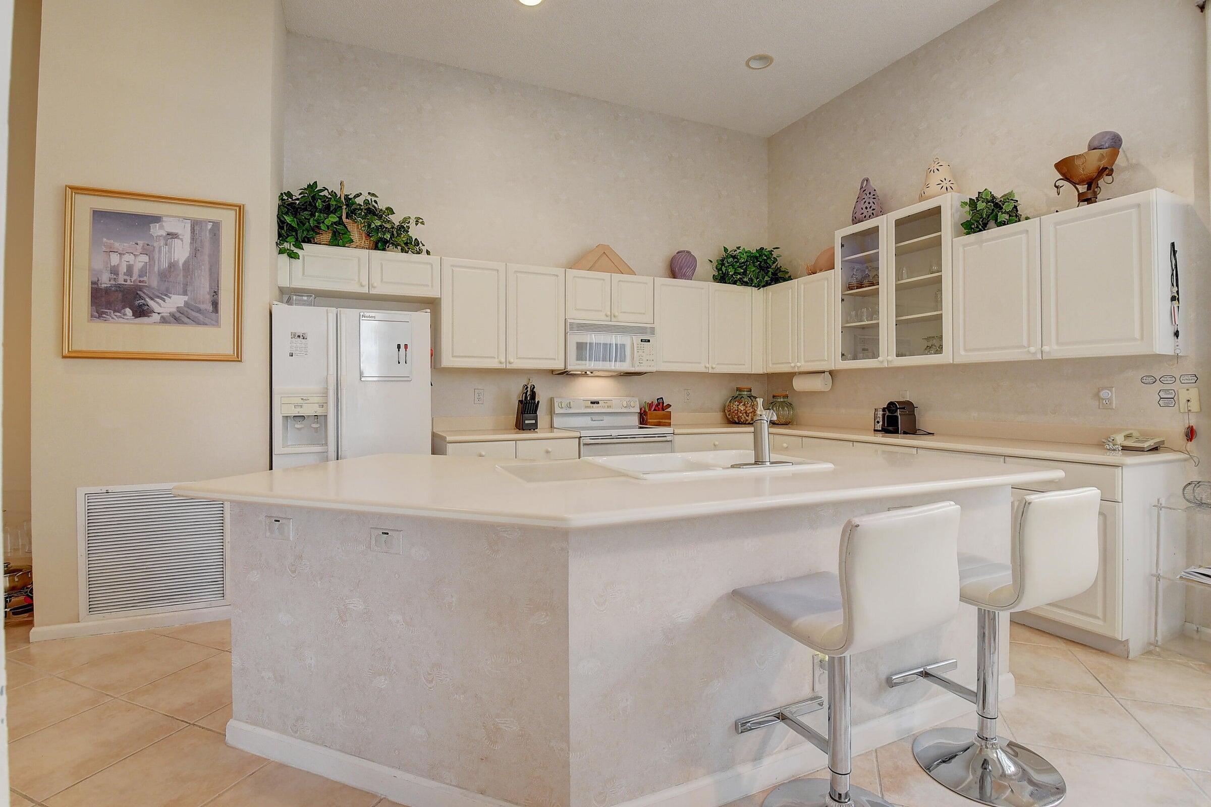 7725 Rockford Road Boynton Beach, FL 33472 - Photo 9 of 47 a kitchen with stainless steel appliances granite countertop a sink and a refrigerator