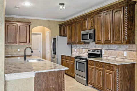 a kitchen with stainless steel appliances granite countertop a sink stove and refrigerator