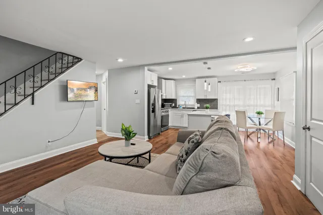 a living room with furniture kitchen and a table