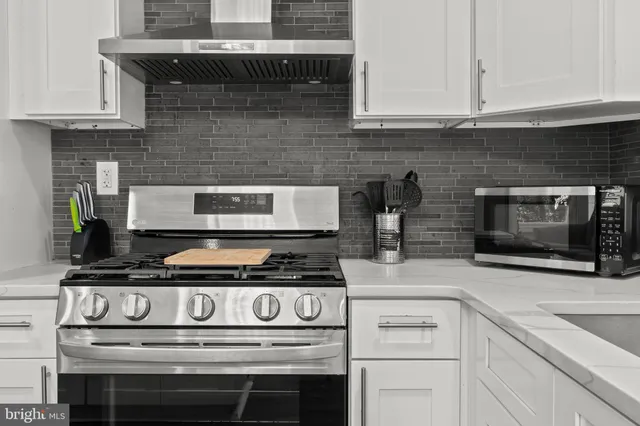 a stove top oven sitting inside of a kitchen