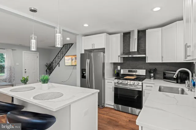 a kitchen with stainless steel appliances a kitchen island a stove a table and chairs