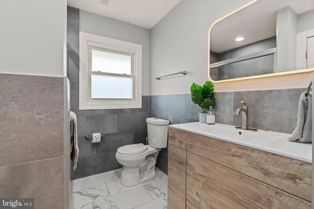 a bathroom with a sink toilet and a mirror