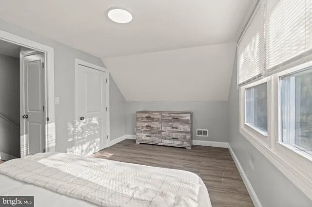 a bedroom with a bed and a large window