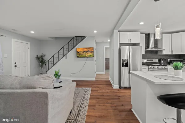 a kitchen with stainless steel appliances kitchen island granite countertop a refrigerator and a sink