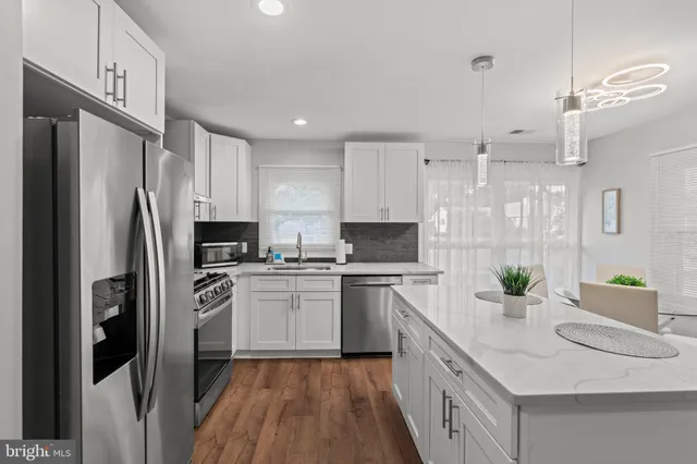 a kitchen with stainless steel appliances a sink cabinets and refrigerator