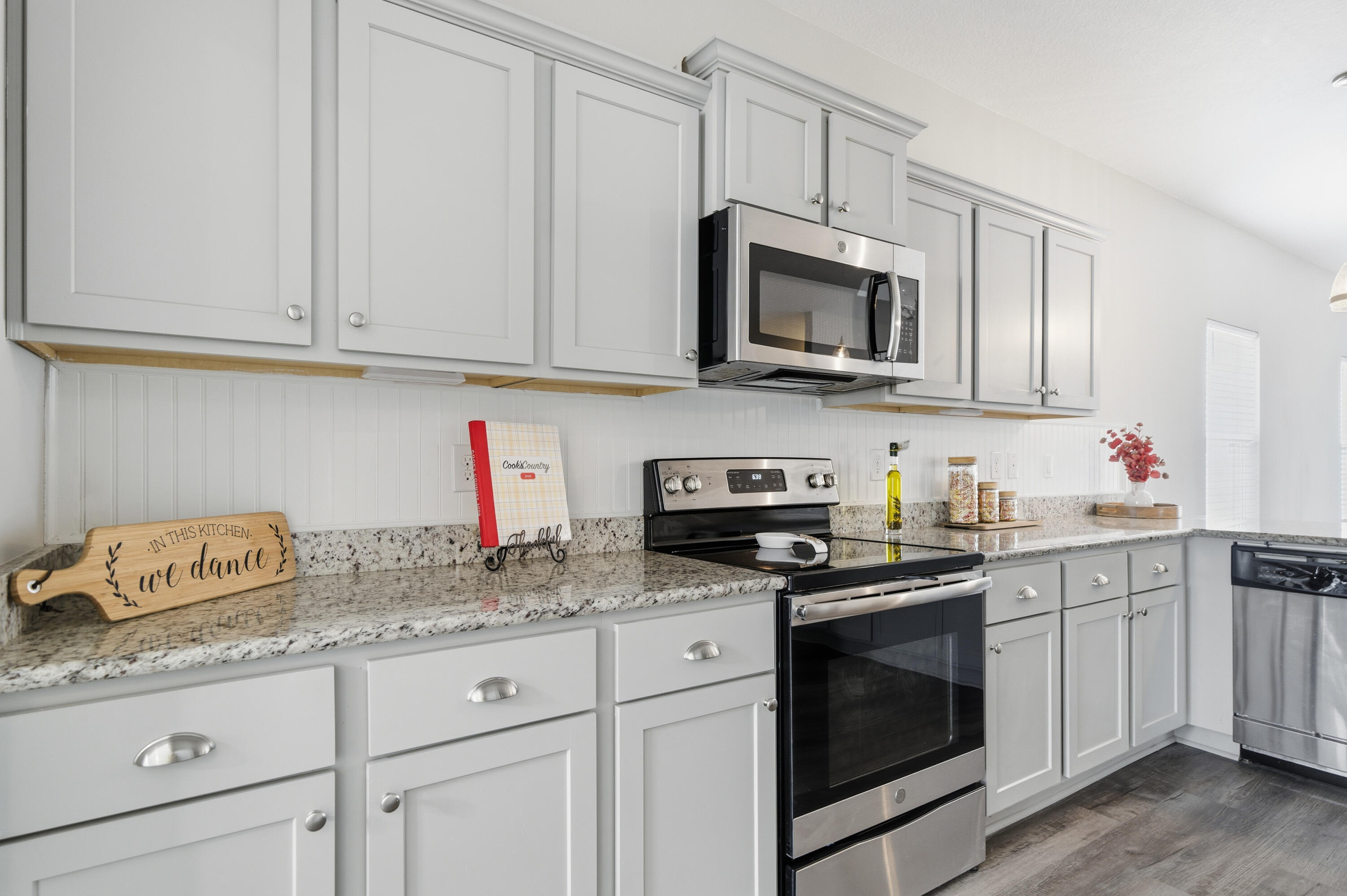 802 Marquis Way Freeport, FL 32439 - Photo 6 of 43 a kitchen with granite countertop white cabinets sink and stainless steel appliances