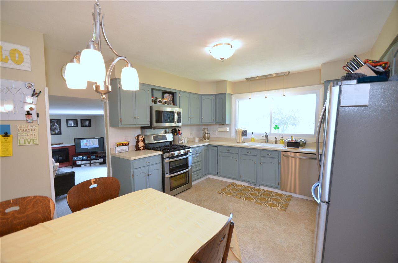 3942 Valerie Road Roscoe, IL 61073 - Photo 7 of 25 a kitchen with stainless steel appliances granite countertop a refrigerator a sink dishwasher a stove top oven a kitchen island and chairs with wooden floor
