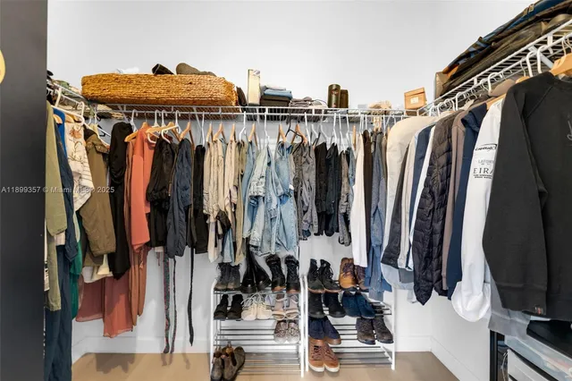 a view of walk in closet with clothes and shoes