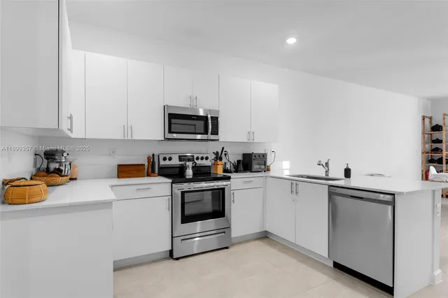 a kitchen with stainless steel appliances granite countertop a sink and white cabinets