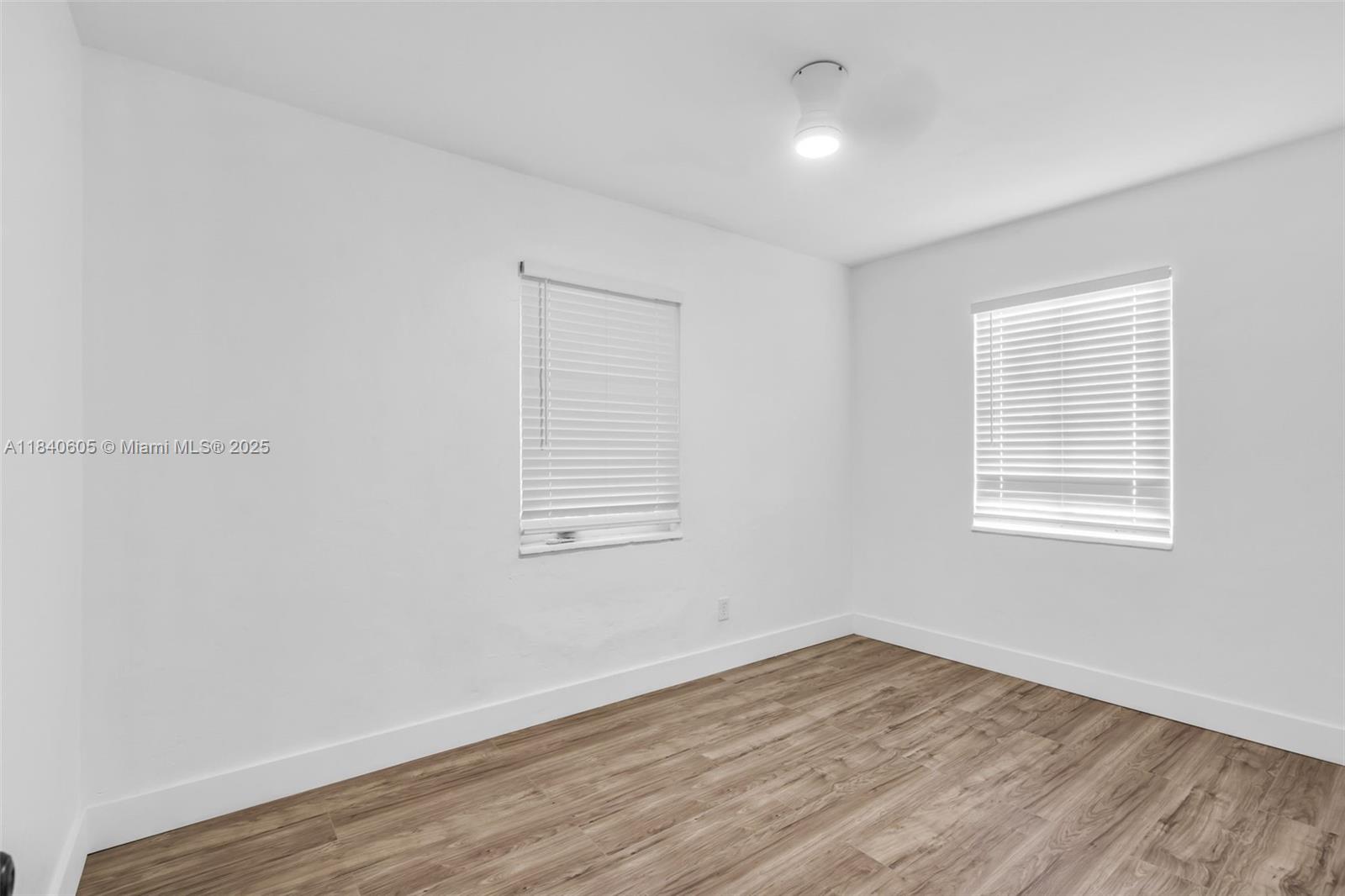 1050 Superior Street Opa-Locka, FL 33054 - Photo 12 of 20 an empty room with wooden floor and windows