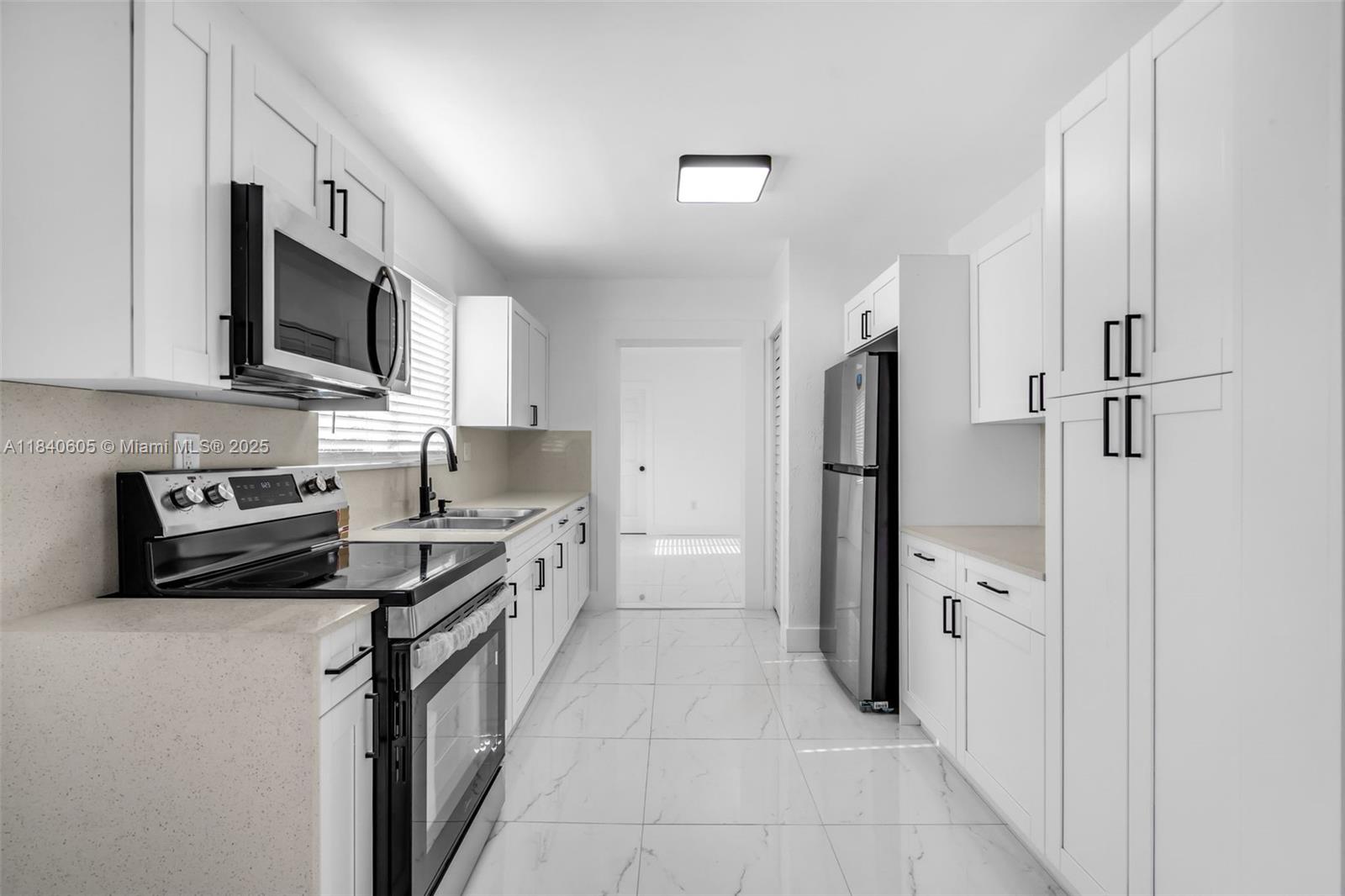 1050 Superior Street Opa-Locka, FL 33054 - Photo 6 of 20 a kitchen with stainless steel appliances a refrigerator sink and microwave