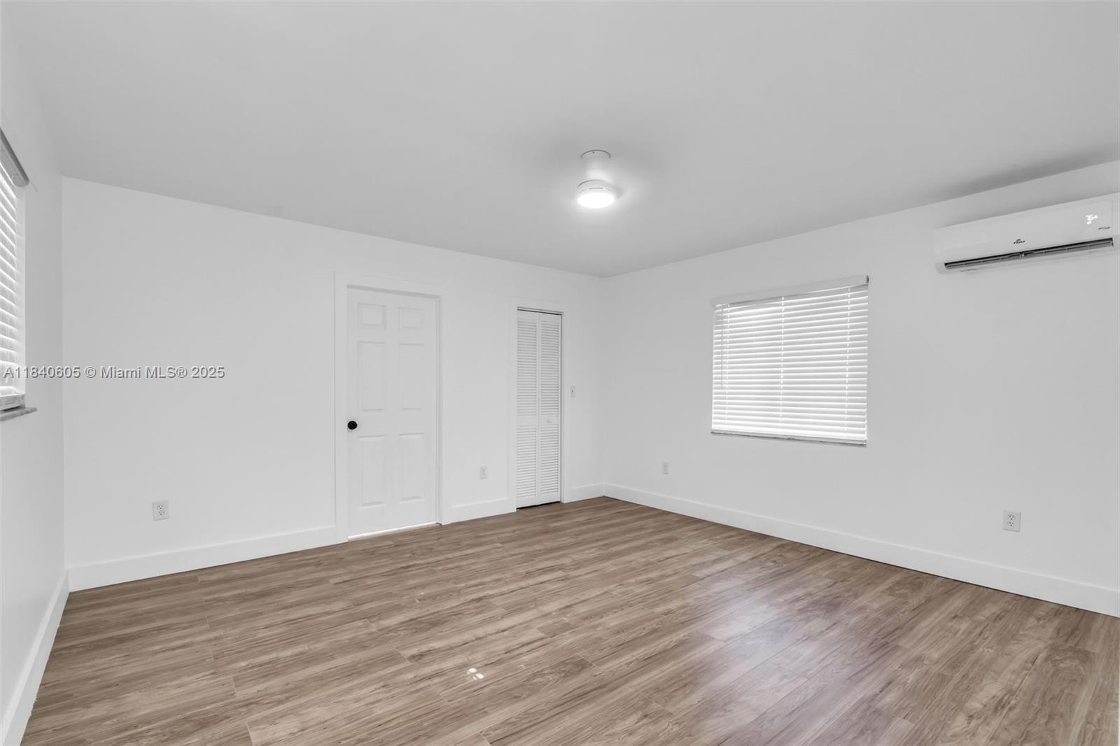 1050 Superior Street Opa-Locka, FL 33054 - Photo 8 of 20 an empty room with wooden floor and windows