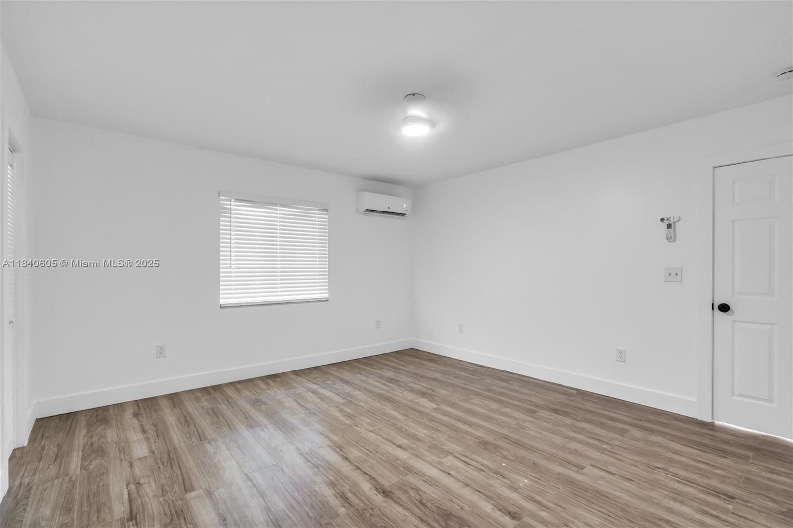 1050 Superior Street Opa-Locka, FL 33054 - Photo 10 of 20 an empty room with wooden floor and windows