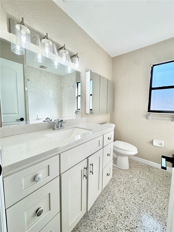 4335 Floramar Terrace New Port Richey, FL 34652 - Photo 11 of 30 a bathroom with a granite countertop sink mirror and toilet