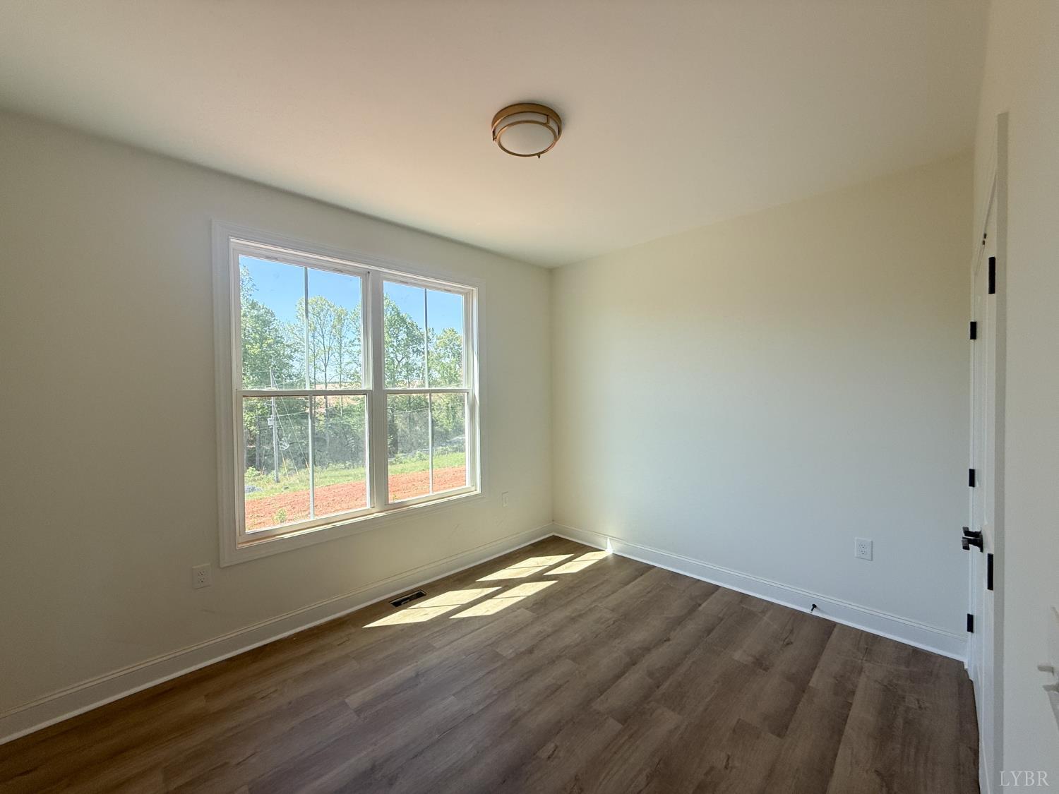9009 Stonewall Road Appomattox, VA 24522 - Photo 16 of 38 an empty room with wooden floor and windows