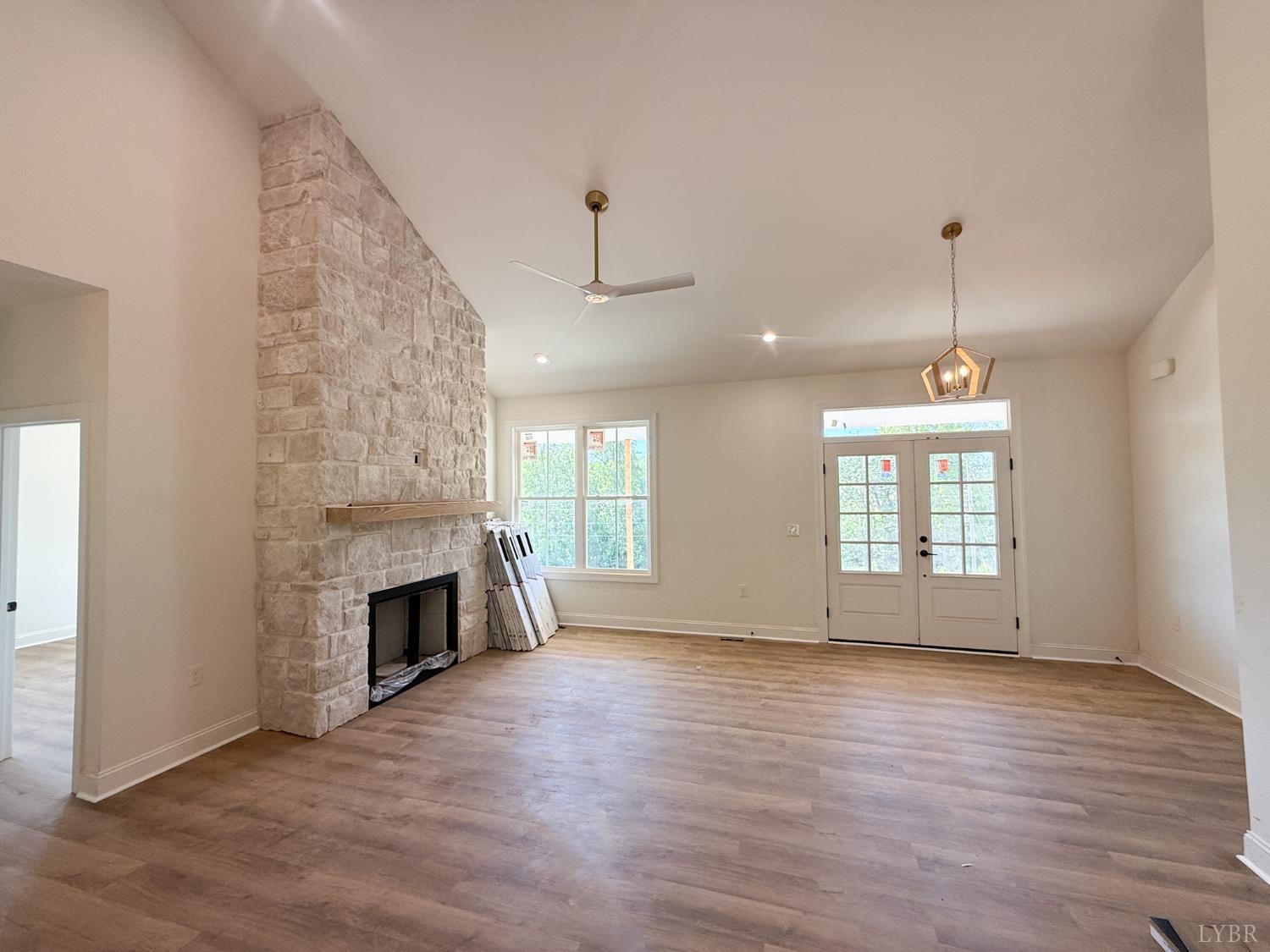 9009 Stonewall Road Appomattox, VA 24522 - Photo 6 of 38 an empty room with wooden floor fireplace and windows