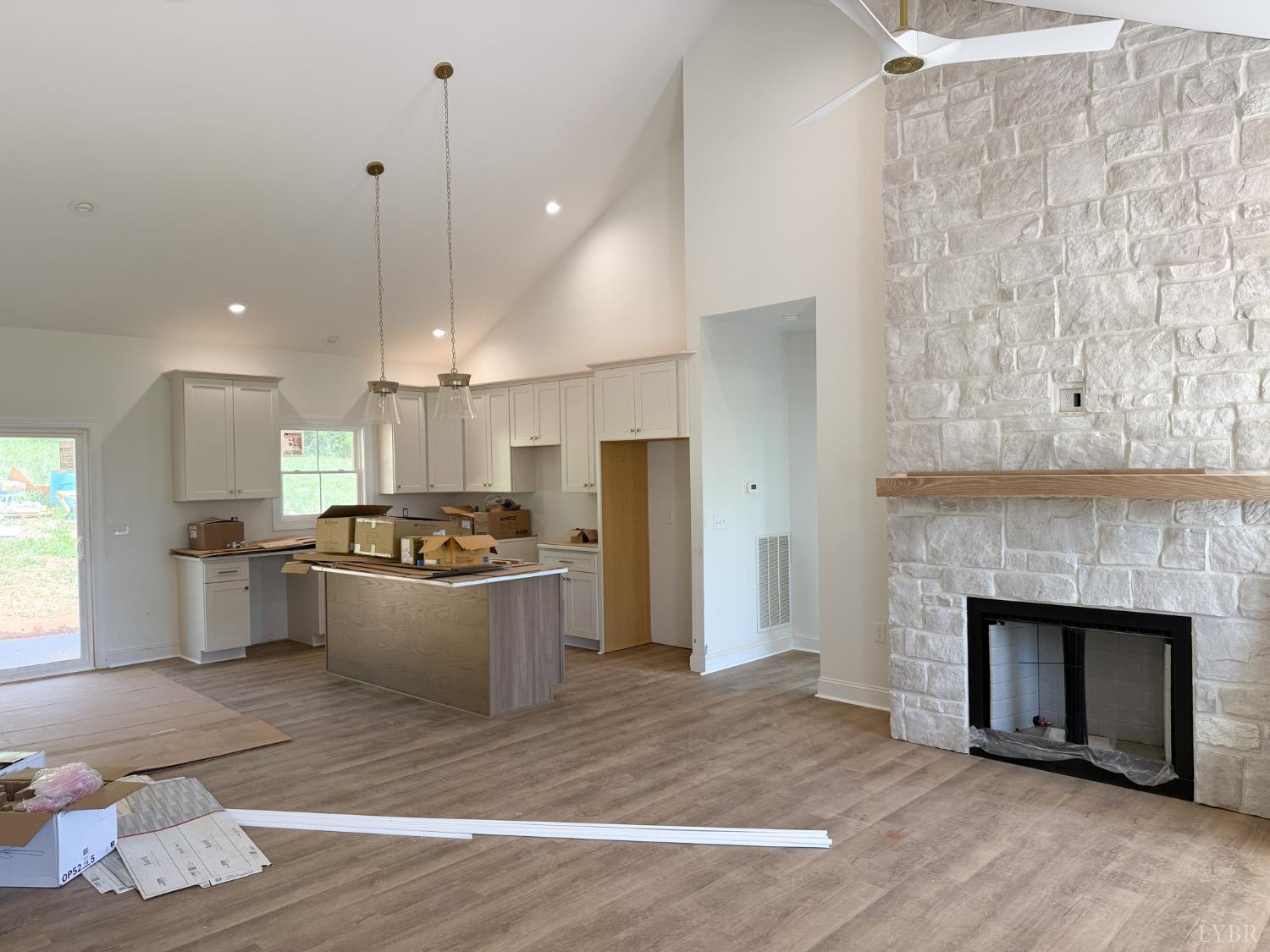 9009 Stonewall Road Appomattox, VA 24522 - Photo 10 of 38 a large kitchen with a wooden floor and a fireplace