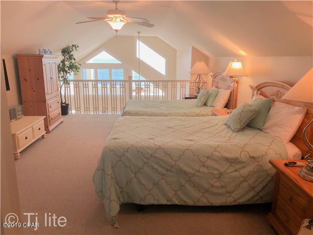 21605 Front Beach Road Panama City Beach, FL 32413 - Photo 12 of 17 a bedroom with a bed and a chandelier