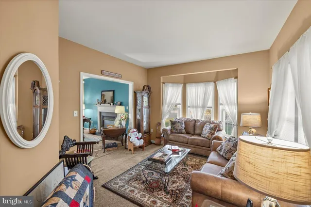a kitchen with stainless steel appliances granite countertop a refrigerator a sink and a view of living room