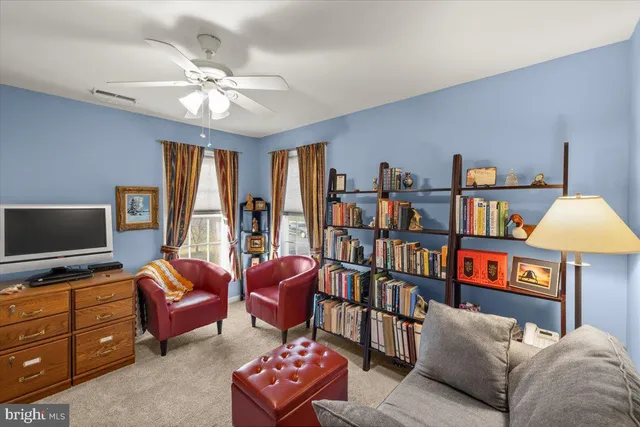 a living room with furniture and a ceiling fan
